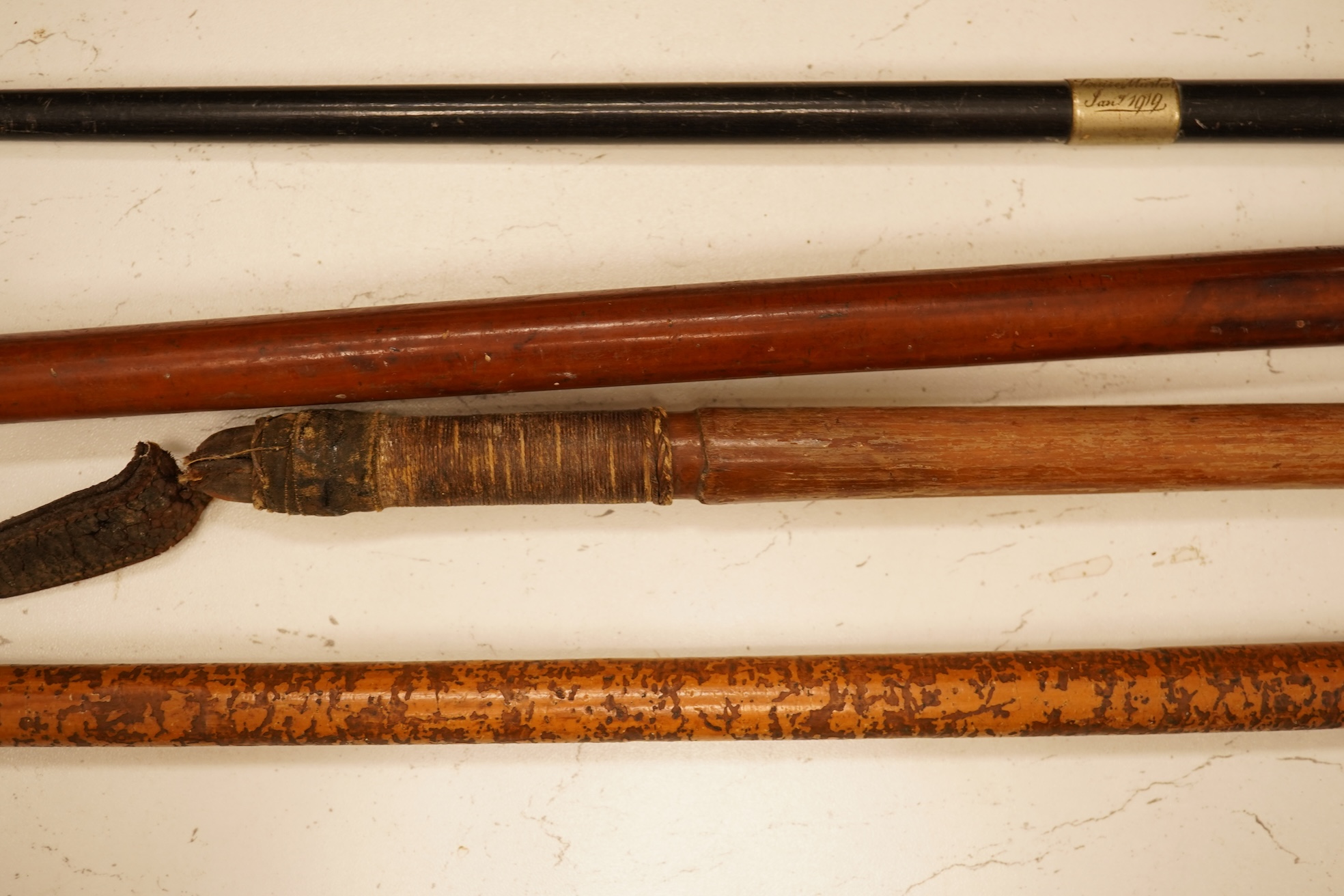Three early 20th century antler handles riding crops with silver mounts and a swagger stick engraved Louise Martin, 1919